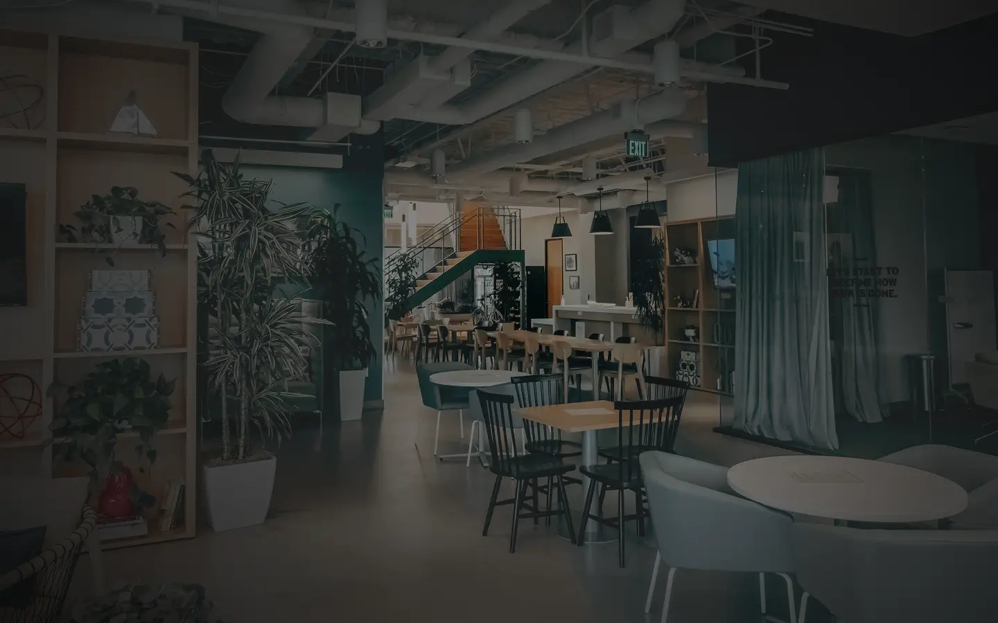 Modern premium coworking space interior at MG Road with wooden shelving, indoor plants, and collaborative seating areas